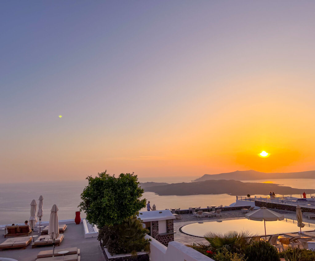 a sun setting over a beach at 7 Steakhouse Fira Santorini sunset restaurants