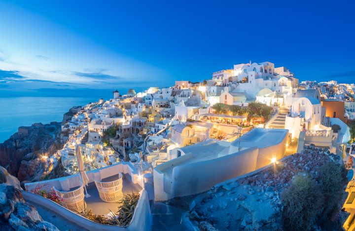 a white buildings on a hill Santorini at blue hour overlooking caldera
