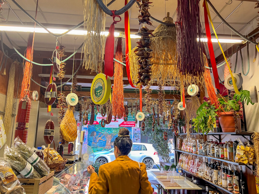 Athens Food Crawl through family shop with dried herbs and sausages hanging